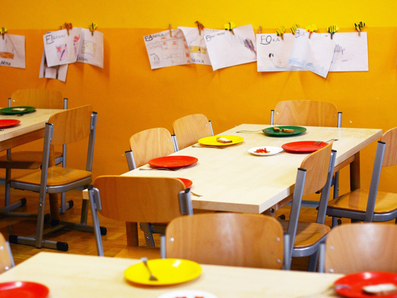 School canteen with red an yellow plastic plates on the tables